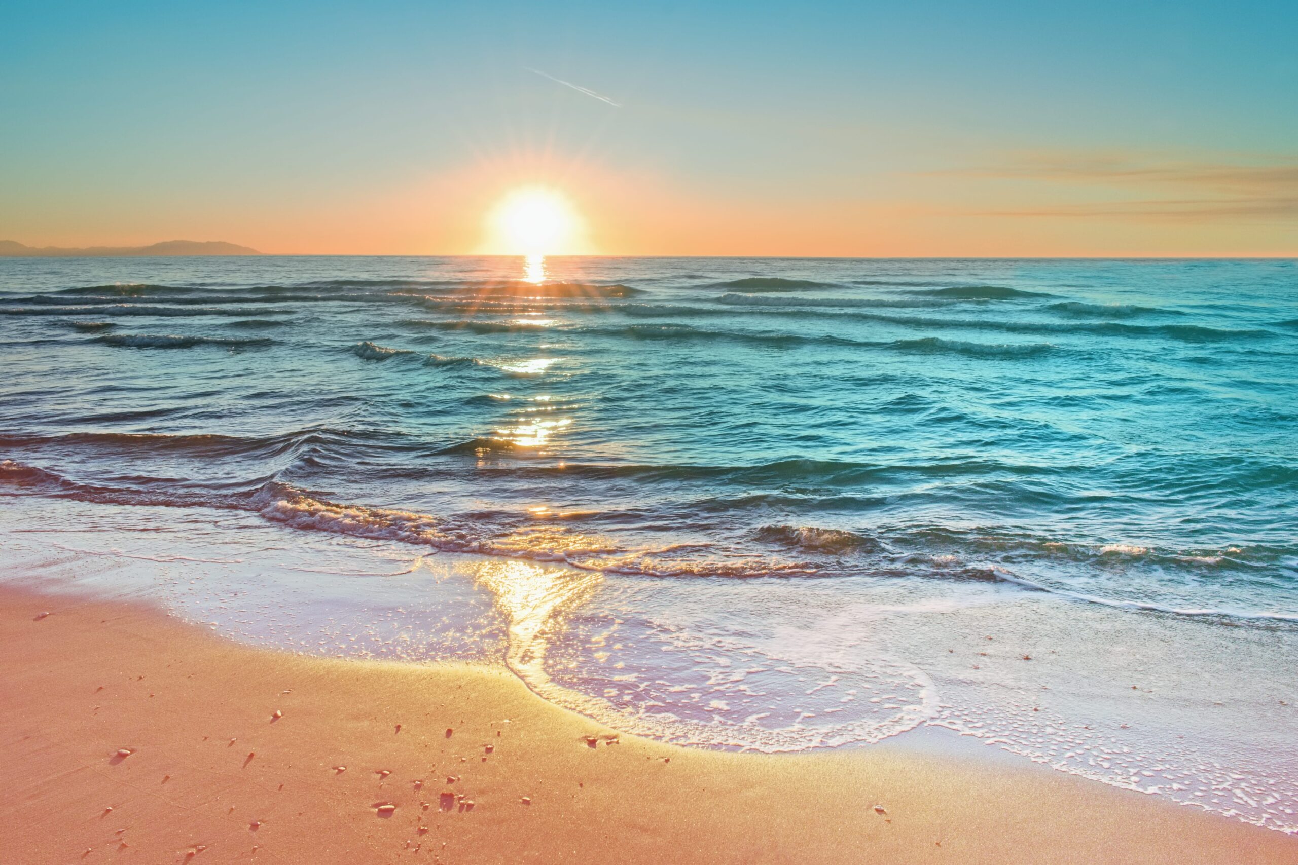 waves on deserted beach at sunset