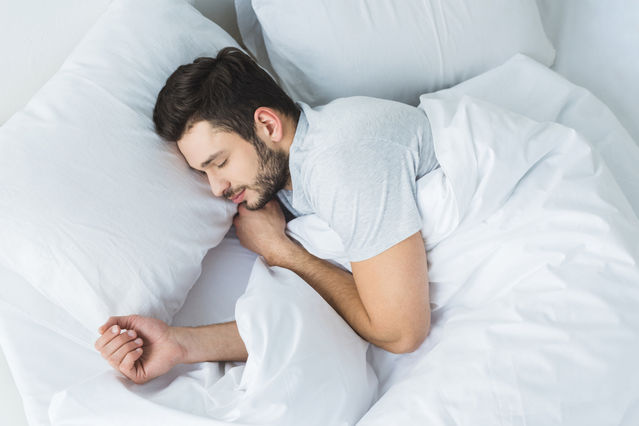 man sleeping in bed after sleep therapy