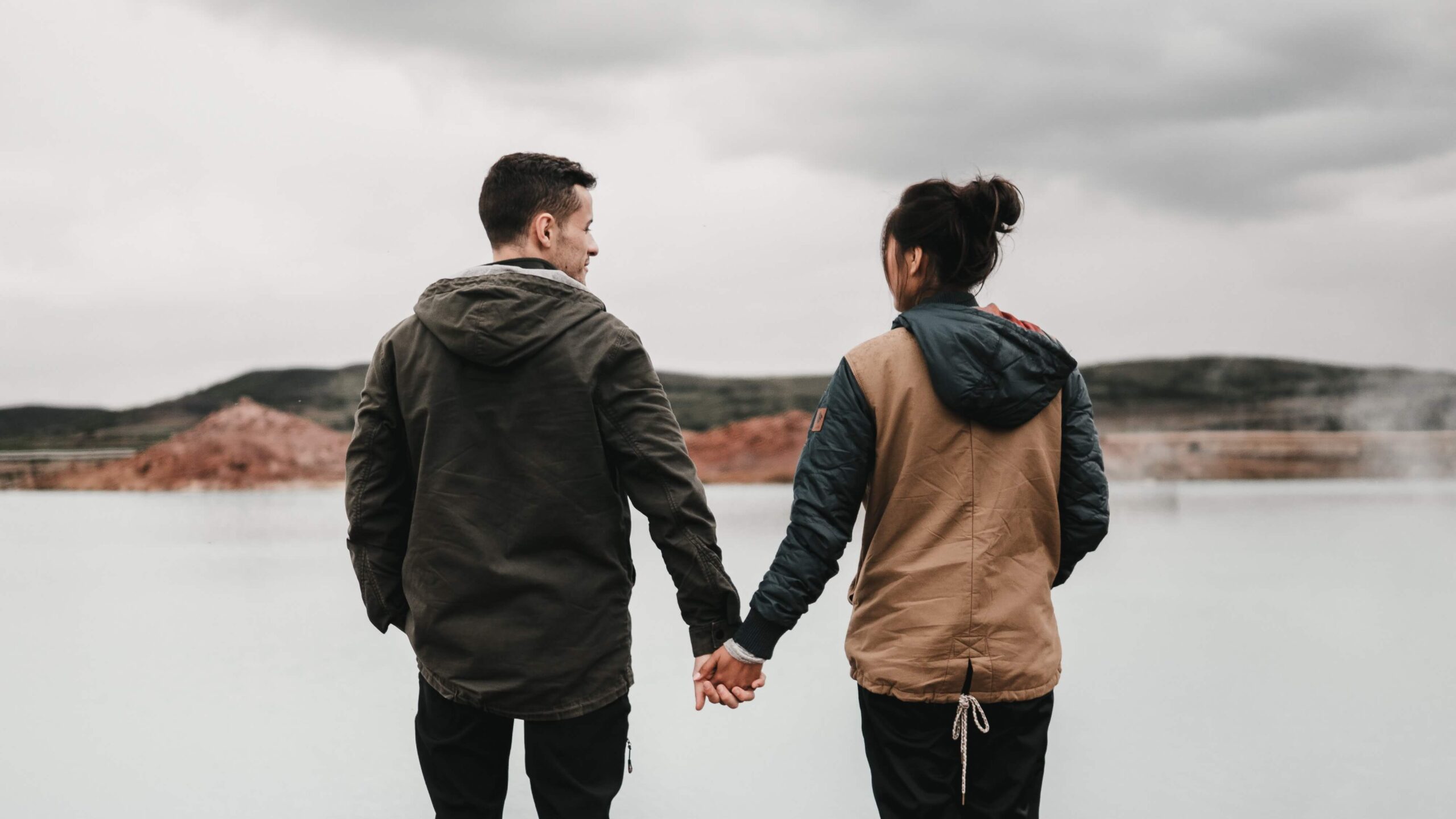 couple holding hands by the sea after couples therapy