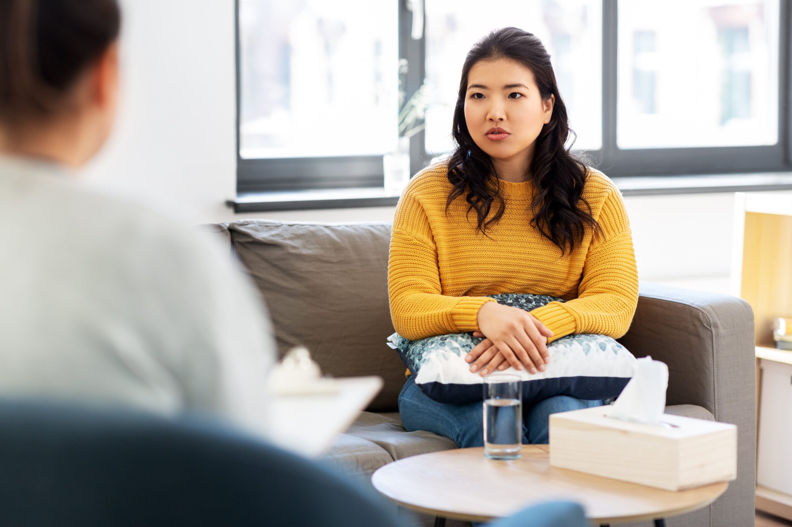 AdobeStock_335196196-min woman sat on sofa speaking to psychologist in London